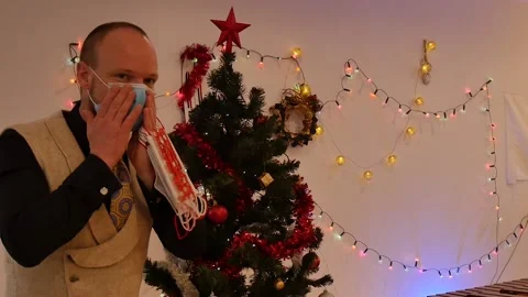 Man in decorating and hanging protective medical surgical face mask on Christmas Stock Footage 145711835