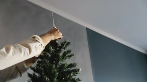 Man decorating christmas tree with red toy Stock Footage 167126889