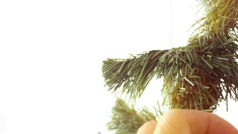 Man decorating Christmas tree with Santa Claus toy on a sunny day at home. Stock-Footage 121522943