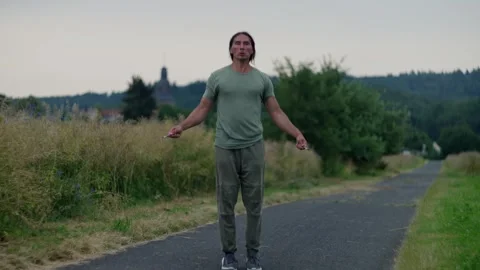 A man is dedicated to his workout routine, jumping rope surrounded by the beauty Stock Footage 303598287