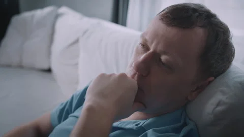 A man, deep in thought and calm, sits on the sofa at home. Stock Footage 319385214