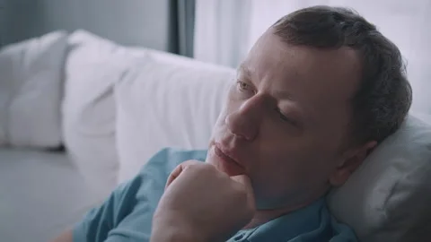 A man deep in thoughtful reflection about life while resting comfortably on a Stock Footage 318313099