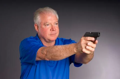Man defends himself holding pointing small semi sutomatic handgun weapon Stock Photos