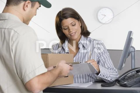 Man Delivering Package For Woman To Sign For