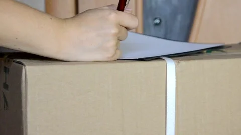 Man delivers goods packed in a box, signing documents 库存影片 133594253
