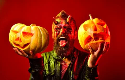 Man demon with pumpkins on red background. Halloween concept. Funny character Stock Photos