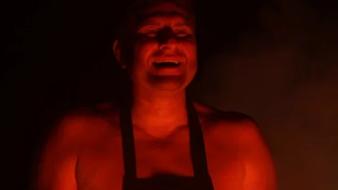 Man demonically laughs, performs a ritual in the light of fire at night Stock Footage 100740986