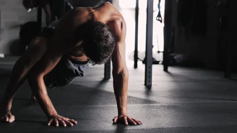 Man demonstrates impressive one-legged push-ups and flexibility exercises Stock-Footage 312761447
