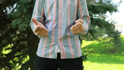 Man Demonstrating Basic Sign Language Gestures in Sunny Park During Afternoon Stock Footage 274127349