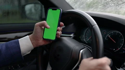 Man demonstrating empty green screen of smartphone in car Stock Footage 205220850