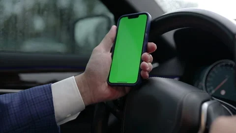 Man demonstrating empty green screen of smartphone in car Stock Footage 205220855