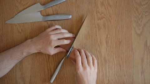 Man demonstrating the knife sharpening process and workflow, top-down view Stock Footage 315209505