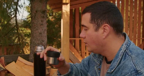 Man in a denim jacket drinking from a thermos cup at a construction site. Break Stock Footage 265005330