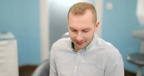 Man in dental braces sits down on the dental chair Stock Footage 147886002