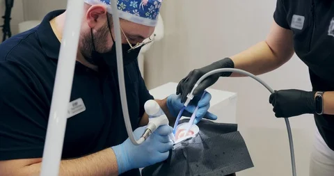 Man dentist's working at office. Two doctors of a dentist do air flow teeth Stock-Footage 129611122