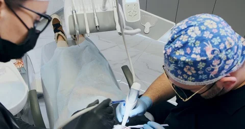 Man dentist's working at office. Two doctors of a dentist do air flow teeth Stock Footage 129611267