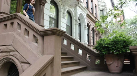 Man descends brownstone stoop 스톡 동영상 25682355