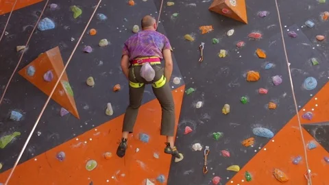 Man descends down the rope from the climbing wall. 1080p resolution Stock Footage 77804263
