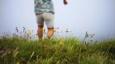 Man descends from the mountain in a strong wind in the fog Stock Footage 101623138