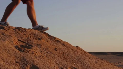 Man descends from the sand dune, sunset Stock Footage 82588401