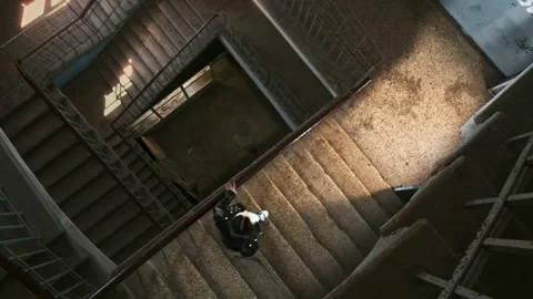 Man descends the steps of a large stairwell with regular geometry Stock Footage 287914873