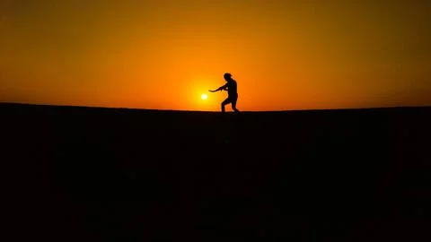 Man in desert during sunset Stock Photos