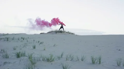 Man in desert with red smoke Stock Footage 77583176