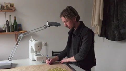 Man designer drawing creative clothing pattern while working in workshop Stock-Footage 100617449