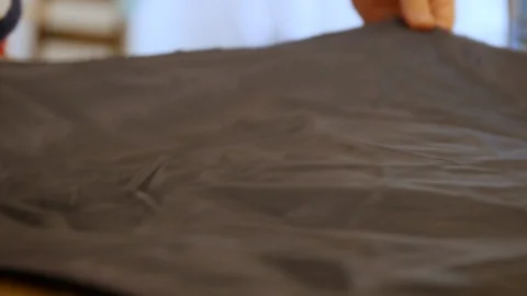Man Designer putting wrinkled lining fabric on wooden table. In sewing and Stock Footage 127259547