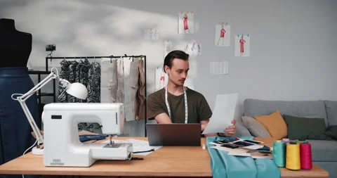 Man designer using a laptop, looking for inspiration during work in the workshop Видео 220147211