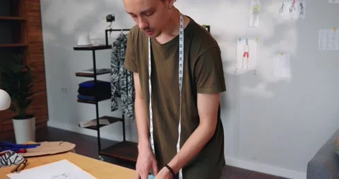 Man designer working in an atelier, choosing color fabrics for design of clothes Stock Footage 220146895