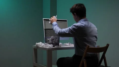 Man at desk overwhelmed by creative block and stress, tossing crumpled drafts Stock-Footage 344605316