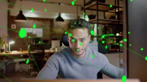 Man at desk reaching to input, initiating tech feed and overlaying green node Video stock 333414075