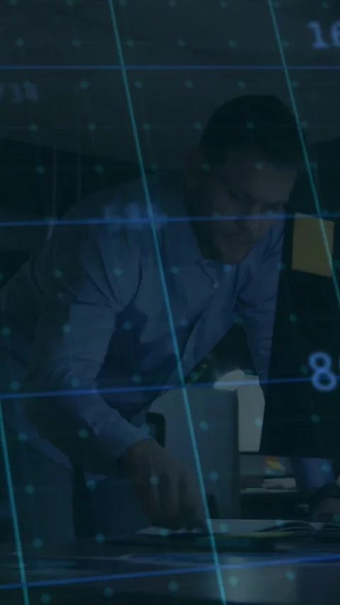 Man at desk reacting to data overlay, studying monitor and writing to fix Stock Footage 331177951