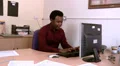 Man at desk stretches and rubs tummy HD Footage