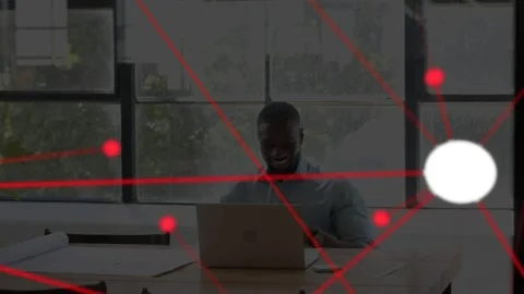 Man at desk tapping laptop, forming red network overlay with white node, smiling Stock Footage 335762228