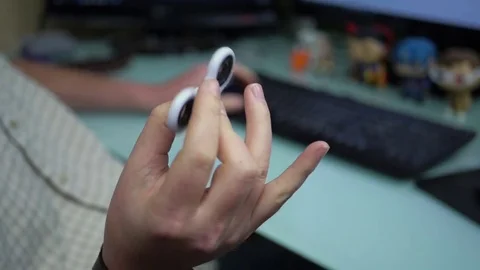 Man at desk using fidget spinner Stock Footage 75790089