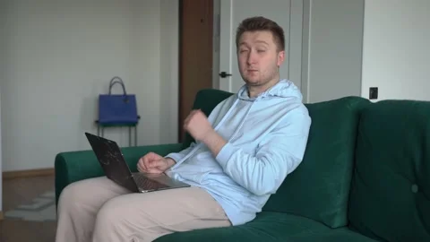 Man, desk, working on laptop, performs order, types message, next lamp is on Stock Footage 154843072
