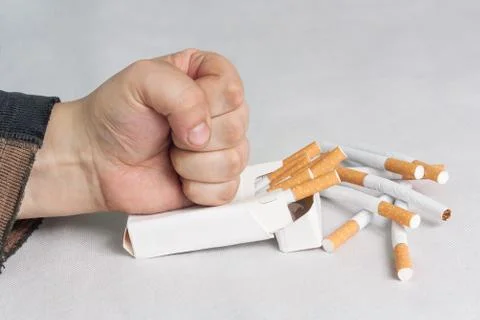 Man destroying a pack of cigarettes Stock Photos