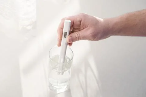Man determines level of total dissolved solids or TDS in drinking water at home Stock Photos