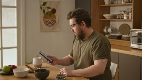 Man with Diabetes Checking Blood Sugar Using CGM Sensor and Phone Stock Footage 336725087