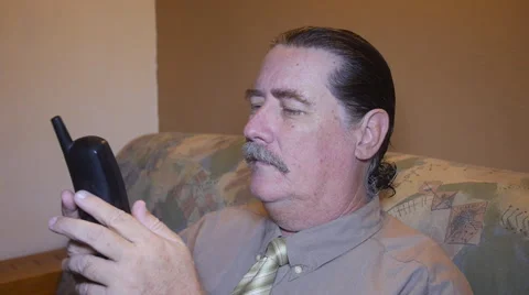 Man dialing and talking on black home wireless telephone Stock Footage 54661413