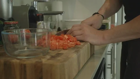 Man Dicing Tomatoes And Putting Them Into Glass Bowl Video stock 121287863