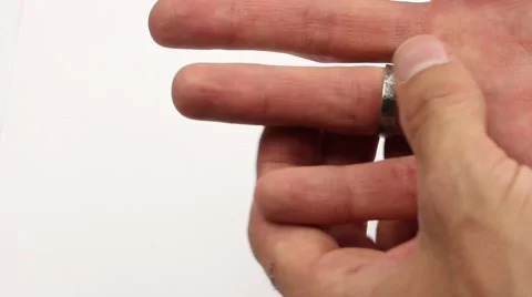 Man with difficulty removes the silver ring from his finger, white background Video stock 57197445