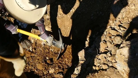 A man digging in the desert with a Pickaxe Stock-Footage 71940110