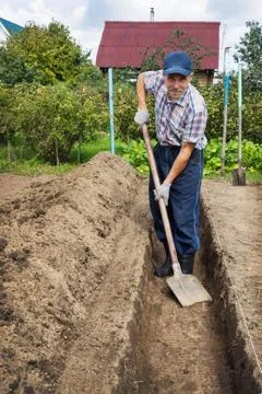 Man digging the earth to build a deep bed of Stock Photos