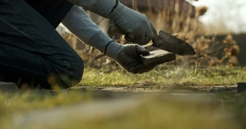 Man digging the ground to make a path from stones. Stock Footage 128321036