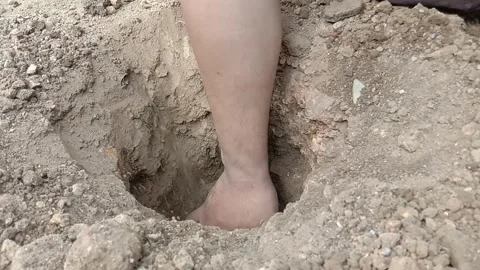 Man digging a hole in the ground using a hand Stock Footage 287094360