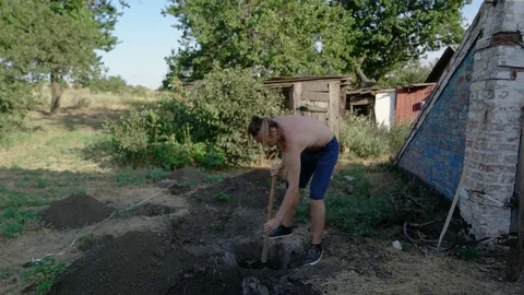 The man digging a hole with a shovel in the ground Stock Footage 80758310