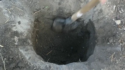 The man digging a hole with a shovel in the ground. Close up shot in 4k Stock Footage 80759221
